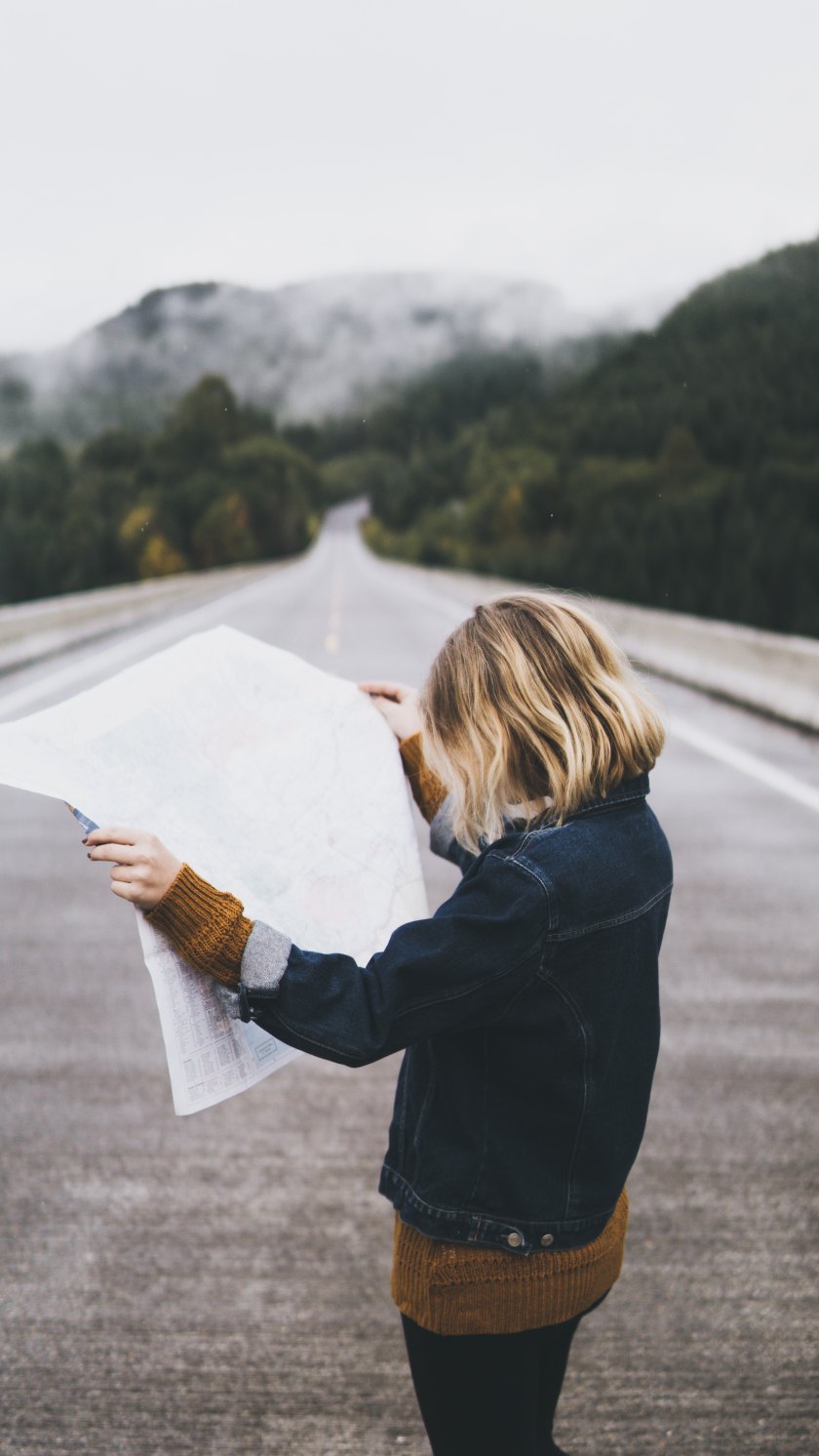 woman reading a map standing in the road