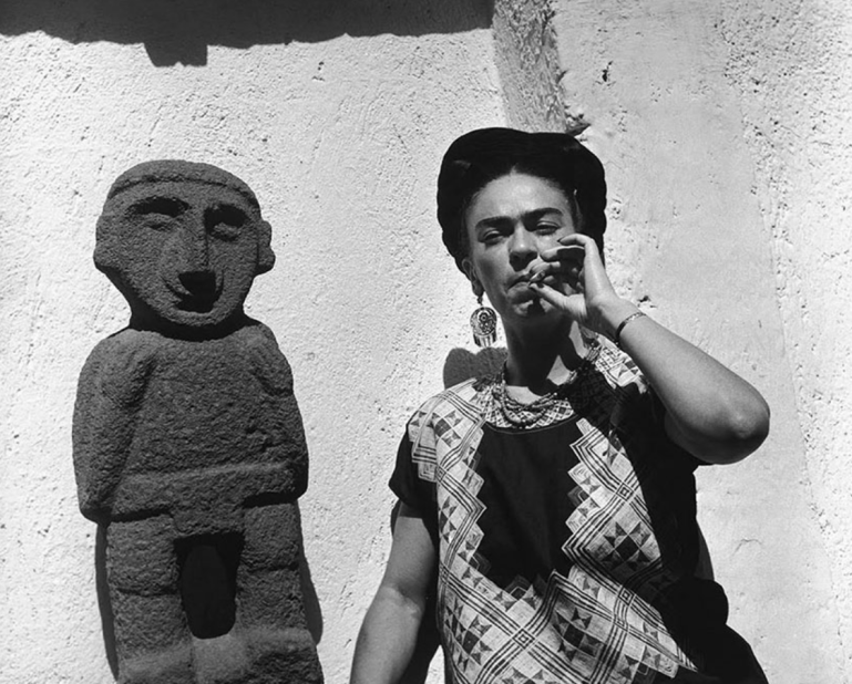 Frida Kahlo smoking with pre-Columbian statue