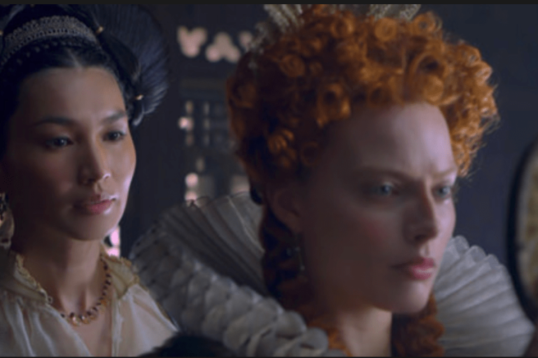 Robbie as Elizabeth I in Mary Queen of Scots having her hair dressed by Bess of Hardwick (Gemma Chan)
